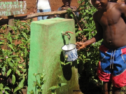 Boy getting clean water from a faucet in Madagascar